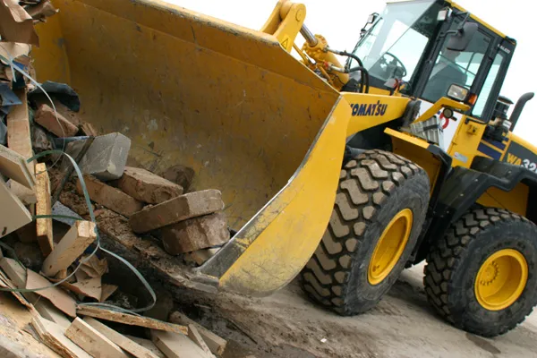 Wheel loader clearing timber and rubble from a demolition site
